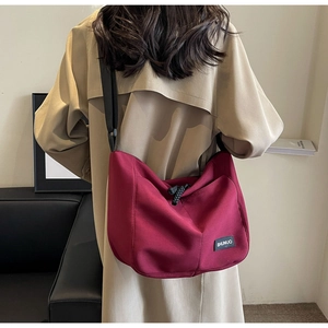 Detail of burgundy nylon tote bag with adjustable shoulder strap and SHUNUO brand label