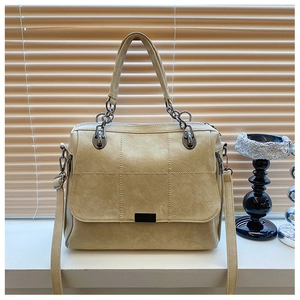 Dettaglio borsa beige in ecopelle trapuntata con trama litchi e fibbia metallica