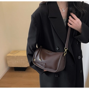 Detail of dark brown lychee pattern leather Boston bag with metallic zipper and tassel