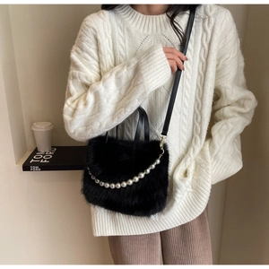 Detailansicht der flauschigen schwarzen Beuteltasche mit Kunstfell und eleganter Perlenkette