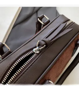 Detail of silver metal zipper and brown textured leather on vintage crossbody bag