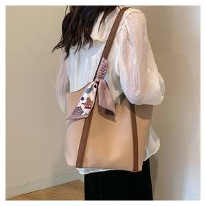 Detail of contrast tote bag with lychee texture and printed silk scarf on the strap