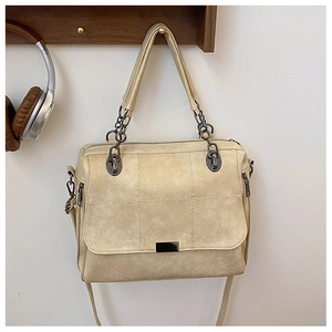 Dettaglio borsa trapuntata beige con tracolla a catena vintage su appendino in legno