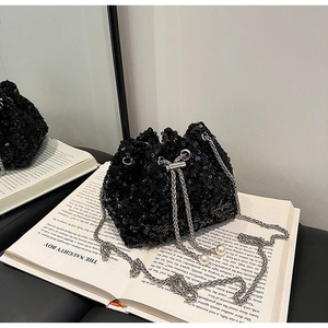 Gros plan détaillé d'un sac seau noir à paillettes avec chaîne argentée et détails perles