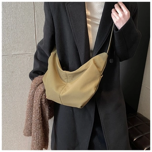 Close-up of olive green crescent crossbody bag showing corduroy texture and strap