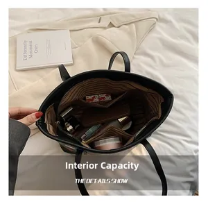 Détail de l'intérieur spacieux d'un sac cabas noir avec doublure rayée et compartiments