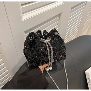 Détail du sac seau à paillettes noires avec chaîne argentée et cordon à perles blanches