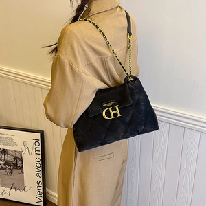 Sac bandoulière matelassé noir élégant avec logo CH en métal doré sur surface texturée