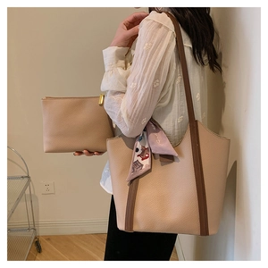 Detail view of beige lychee texture tote bag with brown straps and floral silk scarf