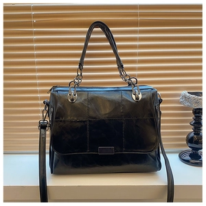 Dettaglio della borsa a tracolla vintage in pelle PU nera con trama trapuntata e catena