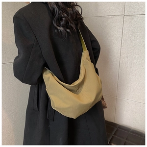 Detail view of large olive green crossbody bag showing texture and size on model