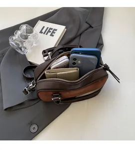 Internal view of the brown leather mini Boston bag showing capacity for phone and wallet