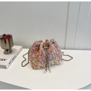 Détail du sac seau à paillettes roses avec cordon perlé et bandoulière en chaîne