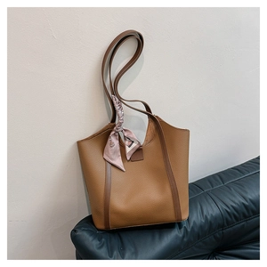 Detailed texture of brown lychee grain leather tote bag with decorative pink floral scarf
