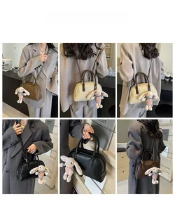 Detailed views of vintage Boston bag shown in crossbody and handheld styles with charms