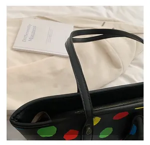 Détail du sac cabas imprimé avec motifs de lèvres colorés et finitions des poignées en cuir
