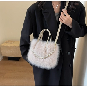 Detailaufnahme einer flauschigen rosa Plüschtasche mit Perlenkette und Lederriemen