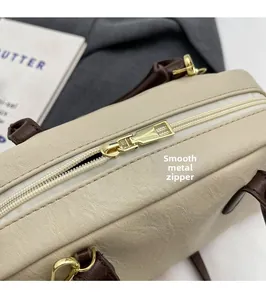 Close-up of golden metal zipper and smooth leather texture on the Boston bag