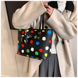 Détail d'un grand sac cabas noir en cuir avec pois colorés et pendentif en forme d'éléphant