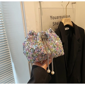 Détail du sac seau à paillettes colorées avec chaîne en métal et breloque en perle