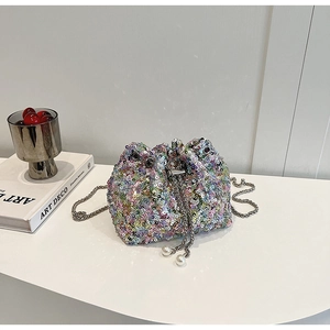 Détail d'un mini sac seau à paillettes avec chaîne argentée et cordon à perles blanc