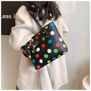 Détail d'un grand sac cabas à pois colorés avec un charmant pendentif éléphant