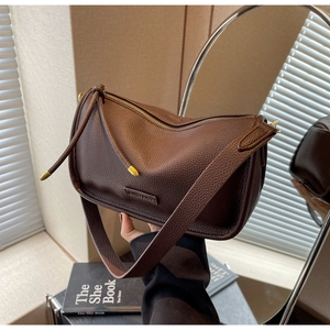 Detail of dark brown pebble leather Boston bag with gold zipper and embossed logo