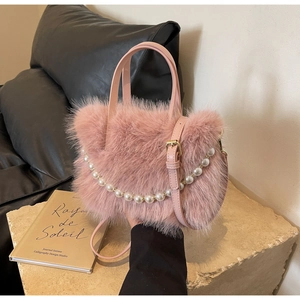Makroaufnahme der rosa Plüsch-Eimertasche mit luxuriöser Perlenkette und Lederriemen