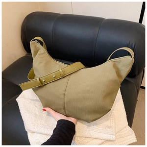Macro view of olive green corduroy crescent bag with textured fabric and zipper