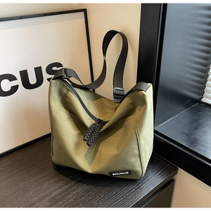Detail of army green nylon crossbody bag showing the adjustable strap and zipper