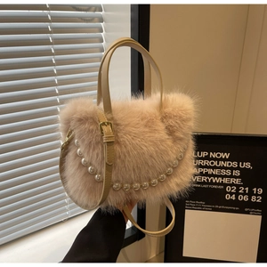 Detail der flauschigen beigen Plüsch-Beuteltasche mit eleganten Perlen und Lederriemen