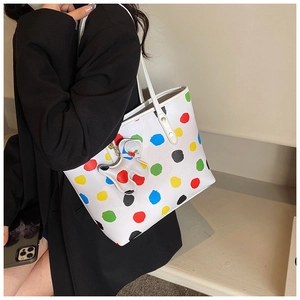 Détail du sac cabas blanc à pois colorés avec charm ours assorti sur la bandoulière