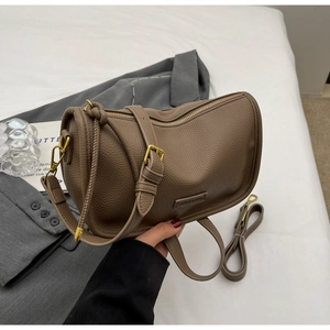 Macro detail of brown litchi pattern leather Boston bag with golden zipper and hardware