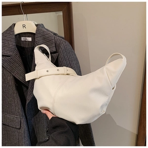 Detail of white pleated moon bag with fine vertical textures and adjustable strap buckle