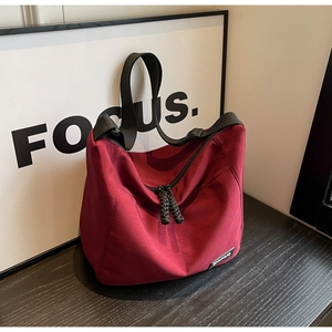 Close-up of wine red nylon tote bag featuring black zipper and SHUNUO brand label