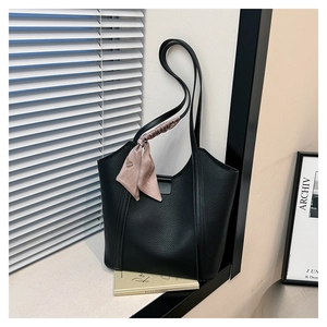 Detail of black tote bag with litchi texture PU leather and decorative pink silk scarf