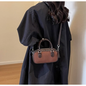 Retro brown suede mini Boston bag with dark leather trim and shoulder strap on model
