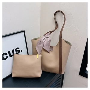 Detail view of khaki pebbled leather tote bag set with a stylish floral silk scarf
