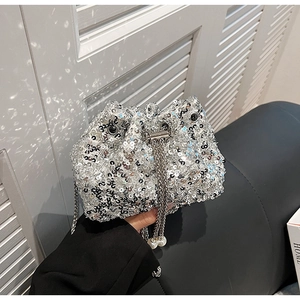 Détail du sac seau à paillettes argentées avec chaîne et perles sur le cordon