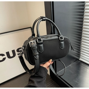 Detail of black faux leather mini square bag showing matte and smooth texture stitching