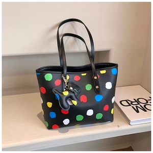 Détail du motif à pois colorés sur le sac fourre-tout en cuir croisé avec charm de chien