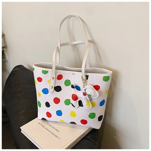 Vue détaillée du cabas blanc à pois colorés avec un accessoire de sac en forme de chien