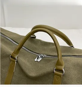 Detail of durable canvas travel bag showing thick leather handles and metal hardware