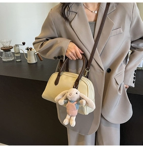 Detail of Boston bag with pink rabbit pendant on a coffee bar background