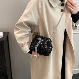 Sac seau élégant à paillettes noires avec chaîne argentée et détails perles sur mannequin