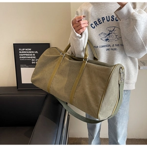 Detail of army green canvas travel bag with leather handles and detachable shoulder strap