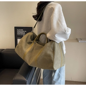 Olive green canvas travel tote with reinforced leather handles and adjustable shoulder strap