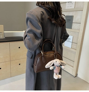 Retro dark brown Boston bag with bunny charm and detachable strap on model