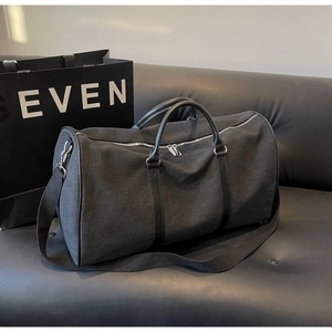 Side view of large canvas travel bag with leather handles and silver zippers