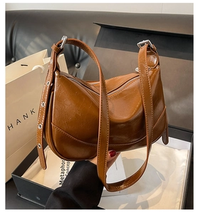 Detail of dark brown retro crossbody bag with pleated leather and silver buckles